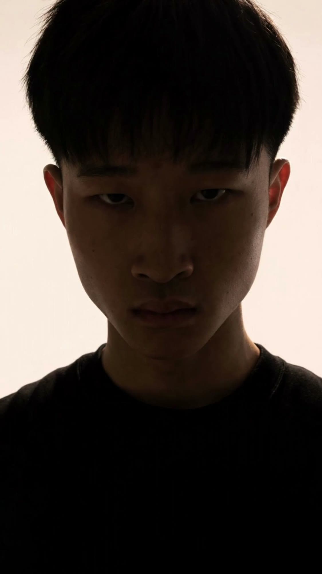 A frame from a reel shot in July 2026: my face in silhouette against a white wall
